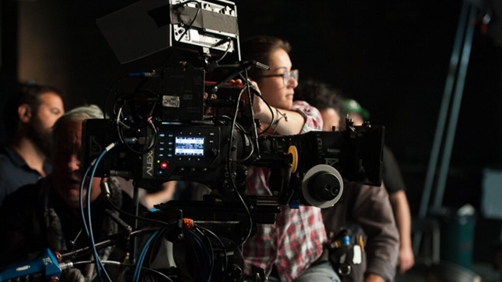 Camera operator filming on a professional video set.