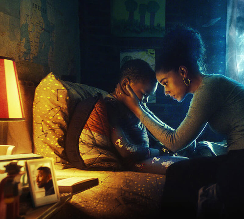Raising Dion Netflix trailer scene of mother holding her son as blue energy appears outside.